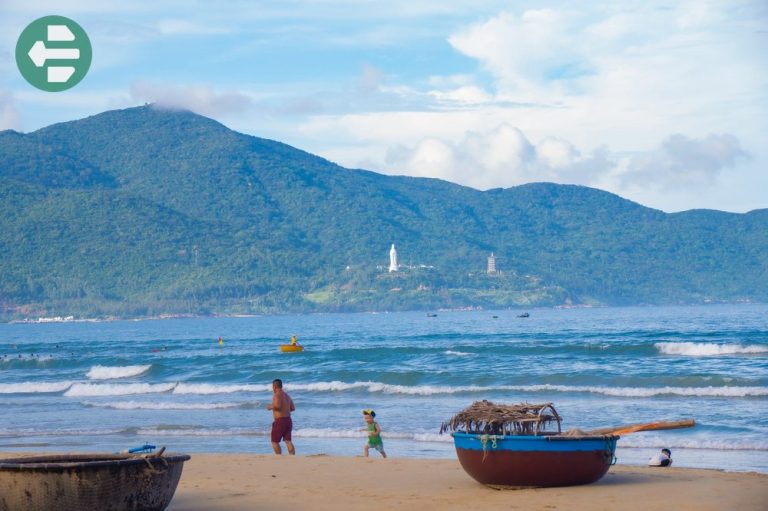 Traditional Vietnamese round boats on Da Nang beach with Son Tra Peninsula mountains in background