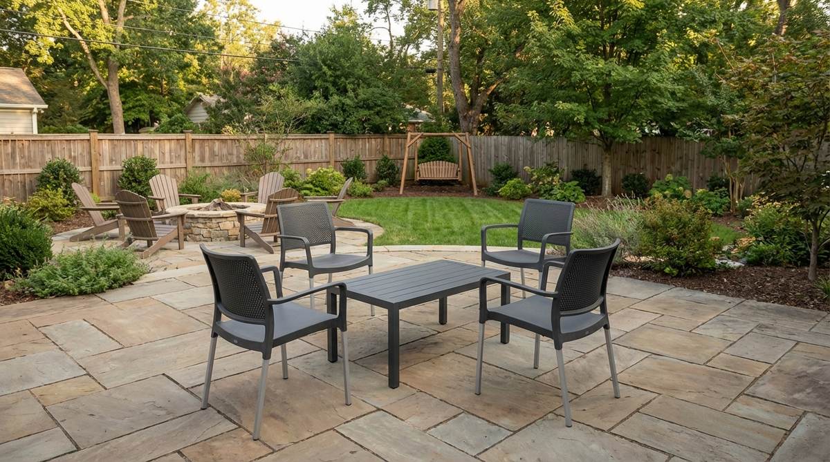 A set of full-arm stackable chairs made from resin or aluminum with slender legs and breathable backs, paired with a contemporary garden table in a matching tone, ideal for multi-use patios that serve as dining, play, and entertaining spaces.