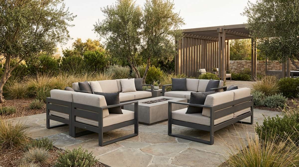 A contemporary outdoor modular seating system in powder-coated aluminum or weather-resistant resin, featuring clean profiles and minimal ornamentation, with cushions in coordinated grays, whites, or earth tones, arranged flexibly in a modern garden setting.
